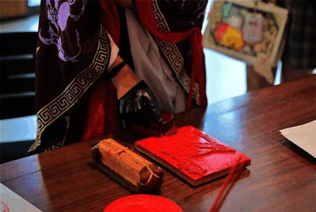 扬州非遗珍宝馆内玩家正在体验雕版印刷的场景