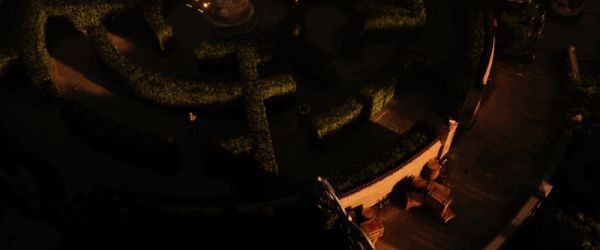 角色在昏暗小巷中谨慎前行，远处有微弱灯光闪烁