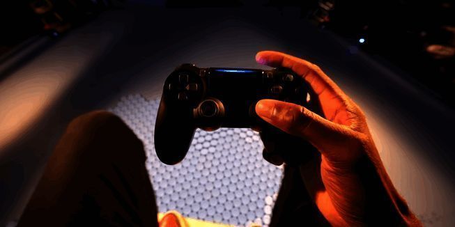 迪士尼乐园内一位游客正使用Steam Deck设备操控着一台双足行走的机器人,背景是充满童话色彩的主题公园景色