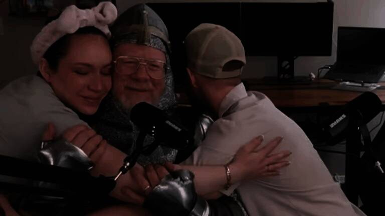 一位年长的父亲坐在电脑前专注地操作游戏手柄,脸上露出认真且享受的表情