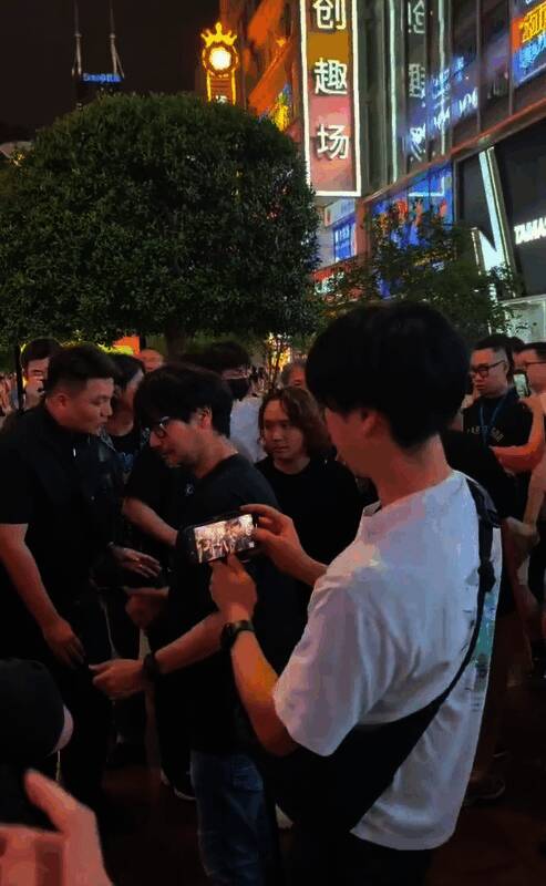 小岛秀夫在上海南京东路街头拍照,周围人群围观