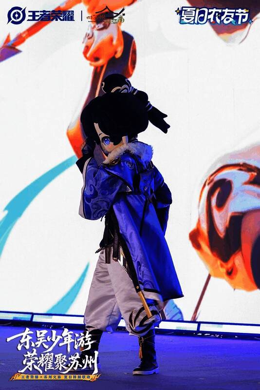 王者荣耀新英雄孙权coser身着苏绣服饰在活动现场展示,背景为苏州丝绸博物馆与非遗传承人联合打造的绣品展示区