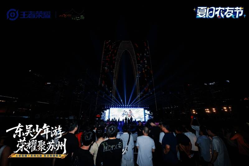 苏州古城街道布置王者主题装饰,游客在打卡点使用NFC功能解锁游戏福利,背景为古街与王者元素融合的灯光布置