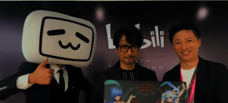 小岛秀夫在BW舞台现场微笑挥手,台下观众高举应援牌,气氛热烈