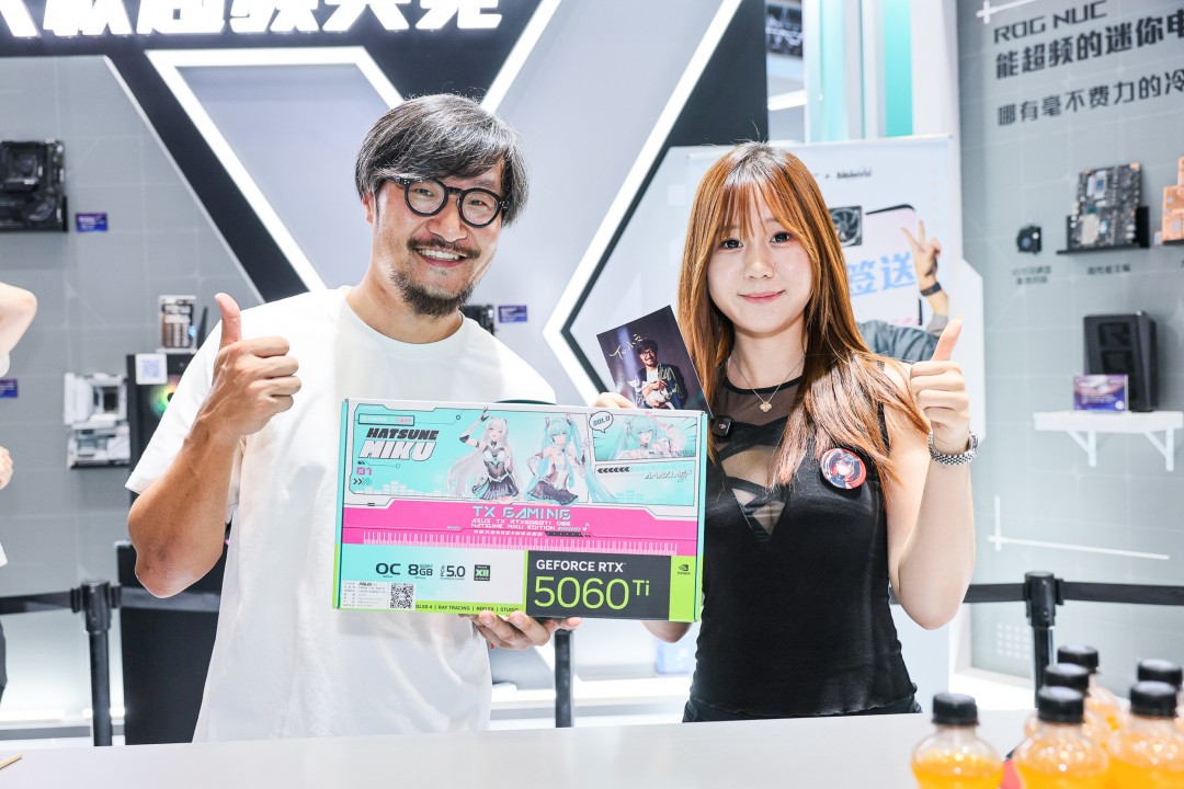 Tony大叔与小岛秀夫并排坐在展台休息区，Tony正指着平板电脑向小岛介绍内容，神情专注而热情