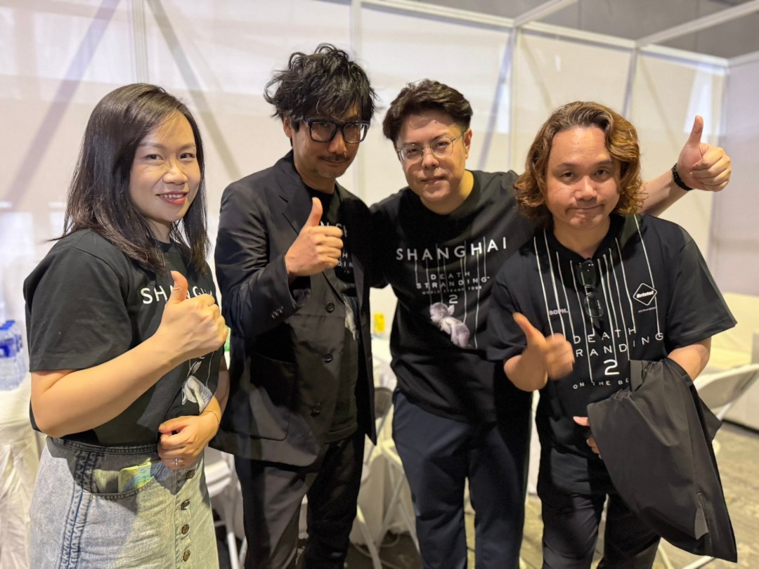 BW2025舞台实拍：徐慧（左一）与曹真（右二）身着简约黑色服装，手持麦克风微笑致意，台下观众举手机拍摄，氛围热烈