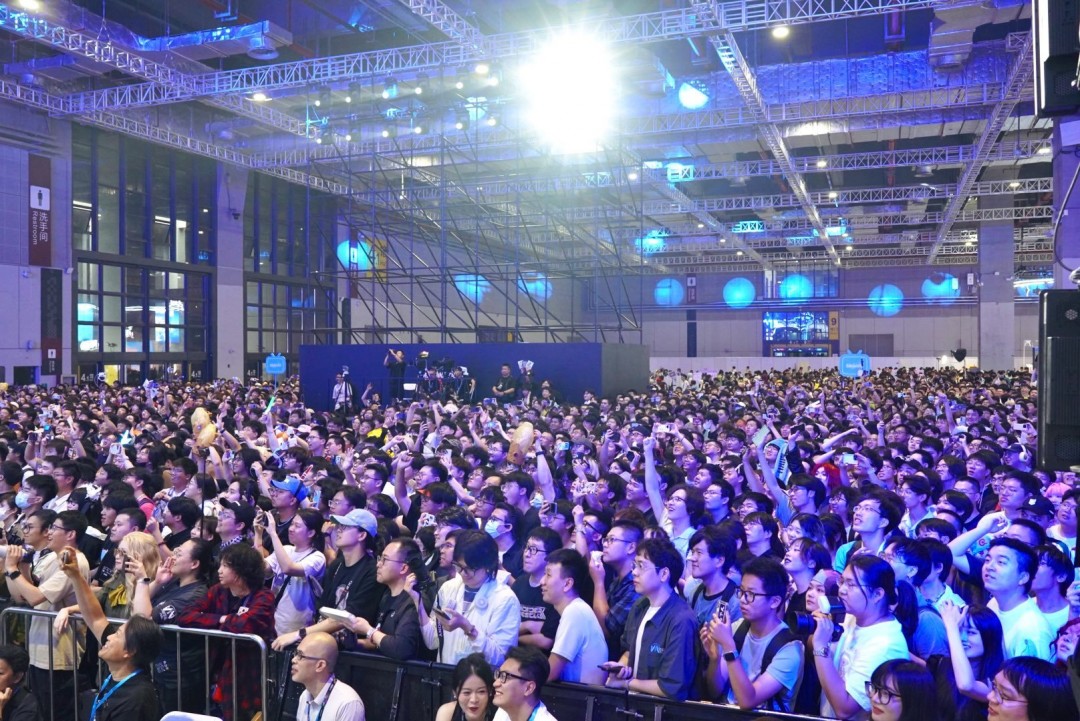 粉丝排队领取限定周边长龙，前方展板印有中英双语标语：‘The Strands Connect Us All —— 连接，从未如此真实’