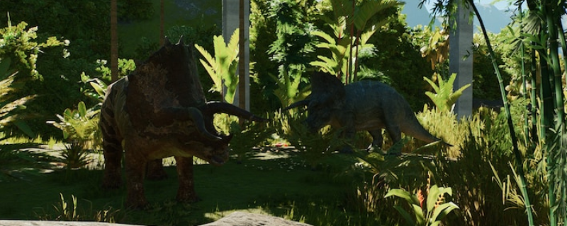 《侏罗纪世界：进化3》游戏内鸟脚类恐龙群居场景：数只色彩柔和的鸭嘴龙状生物在阳光斑驳的蕨类丛林中缓步进食，背景可见木质观景台与远处喷泉