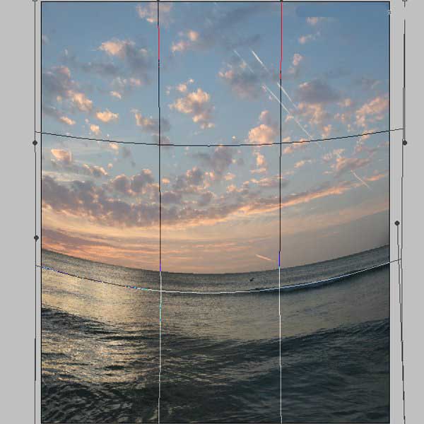 液化滤镜操作特写：鼠标光标正沿海面轮廓做柔和拖拽，界面中可见波纹状网格形变，实时预览出水面起伏的动态效果